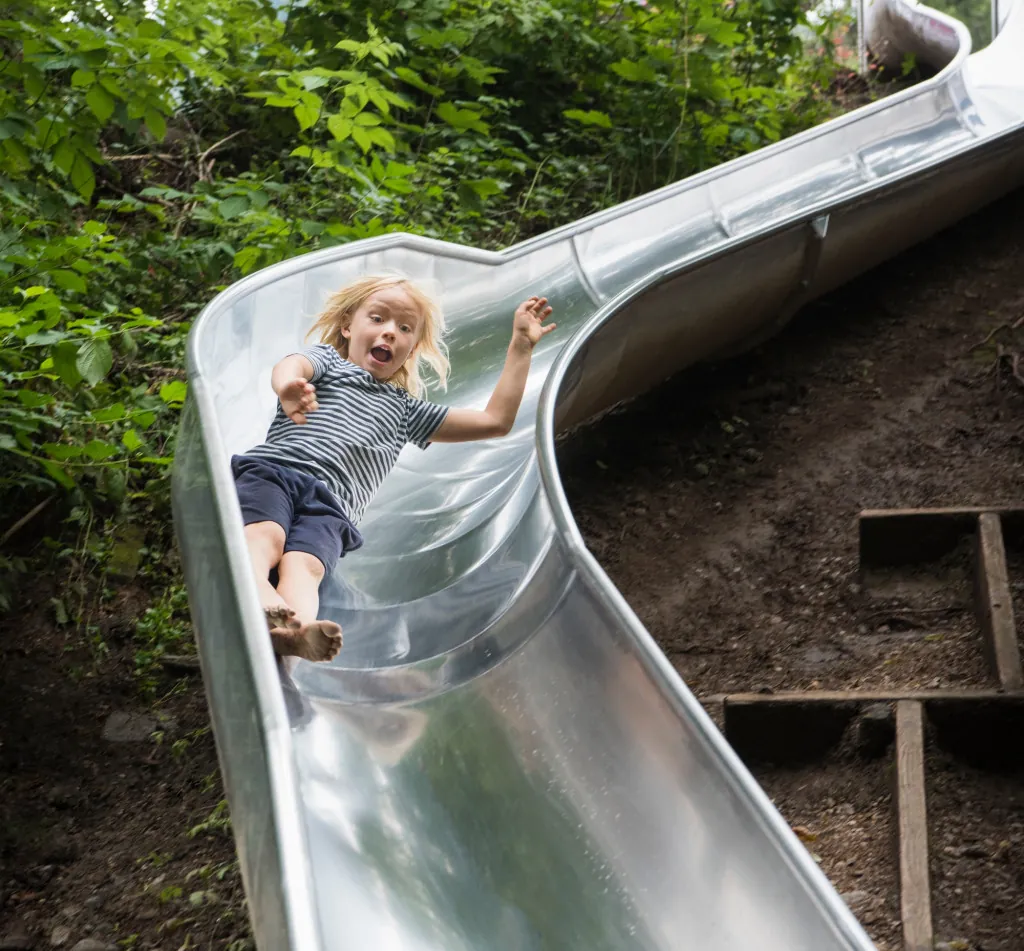 Boy sliding down playground slide